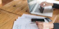 Business woman hand with Financial charts and laptop on the table